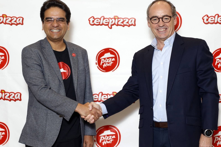 Milind Pant, president de Pizza Hut, i Pablo Juantegui, de Telepizza, es donen la mà després de signar l'acord.