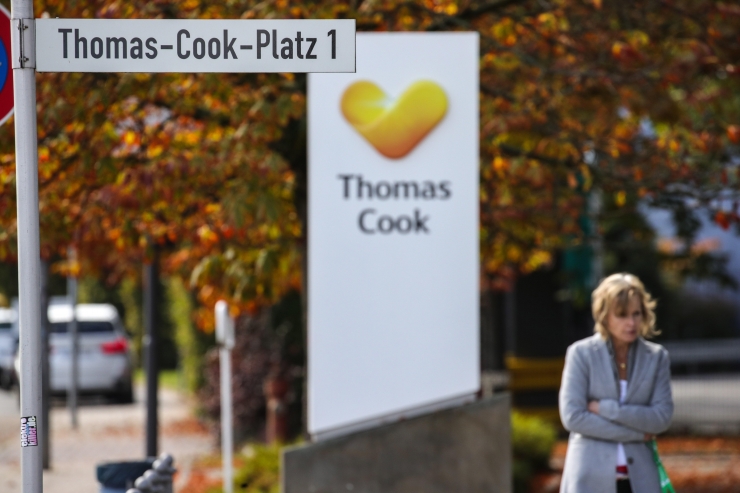 Una dona passeja al costat d'un logotip de Thomas Cook a la ciutat alemanya d'Oberursel.