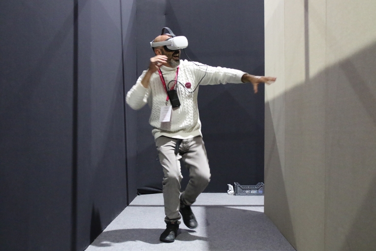 Una persona provant l'experiència immersiva a l'estand d'Andorra Telecom a través d'uns visors de realitat virtual.