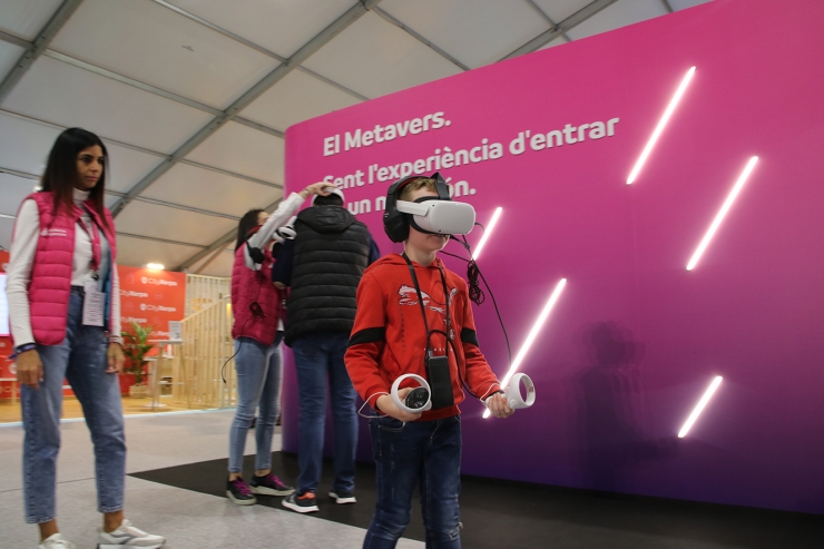 Un nen provant l'experiència immersiva a l'estand d'Andorra Telecom a través d'uns visors de realitat virtual.