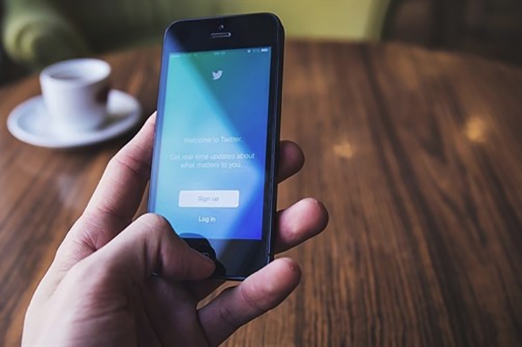 Un usuari utilitza Twitter amb el seu telèfon mòbil.