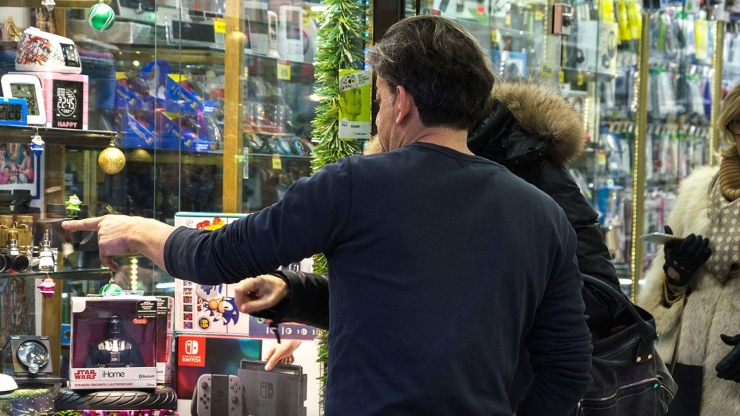 Turistes miren un aparador de l'avinguda Meritxell.