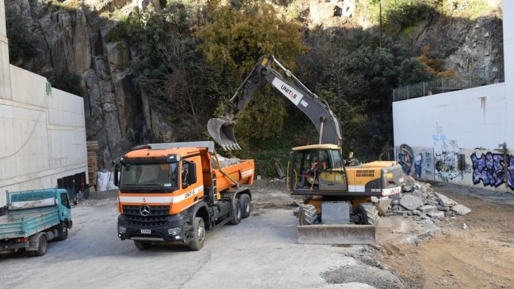 Una excavadora traient terra i pedres per iniciar una obra.