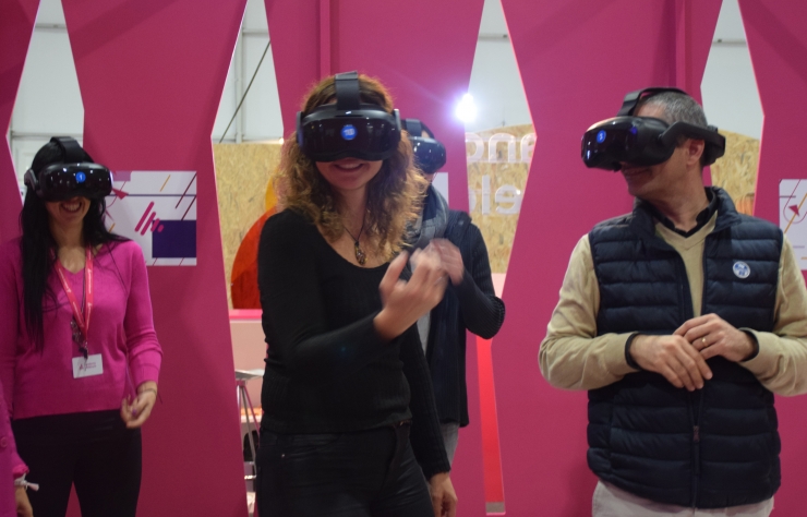 Visitants de la fira gaudint de l'experiència de realitat virtual a l'estand d'Andorra Telecom.