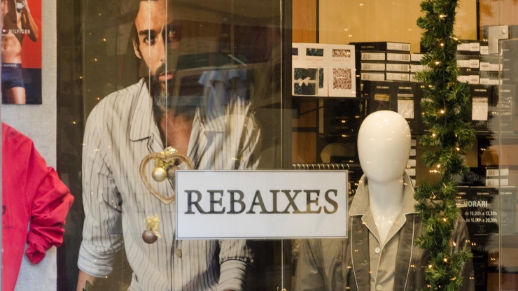 L'aparador d'un comerç amb un cartell de rebaixes.