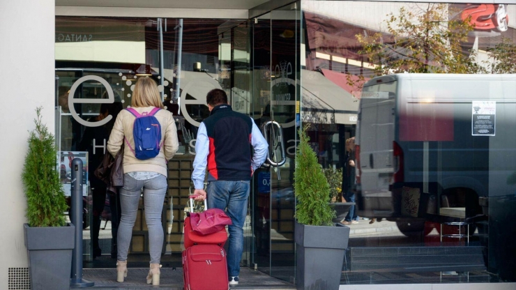 Turistes a l'entrada d'un hotel.